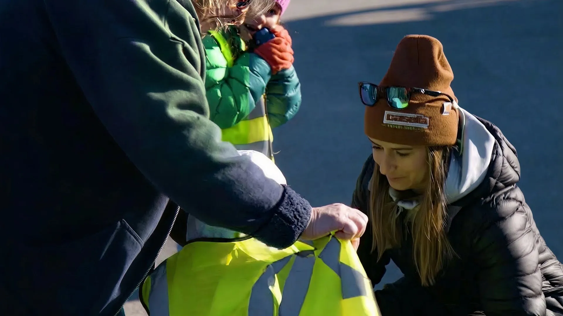 Casella team member showing safety gear to children during an outdoor activity.