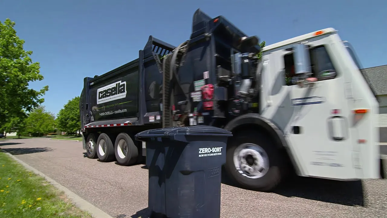 Casella recycling truck collecting a Zero-Sort recycling bin in a residential neighborhood.