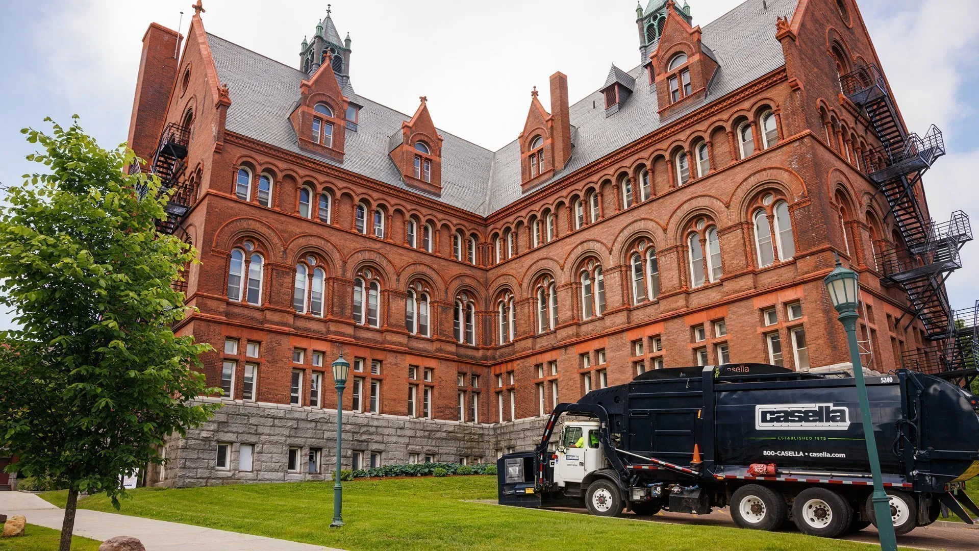 Casella truck parked beside a large historic red brick building.