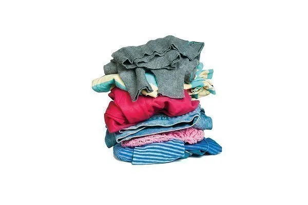 Stack of multicolored clothing with a red prohibition symbol over it, indicating that clothing and textiles are not allowed for recycling. 