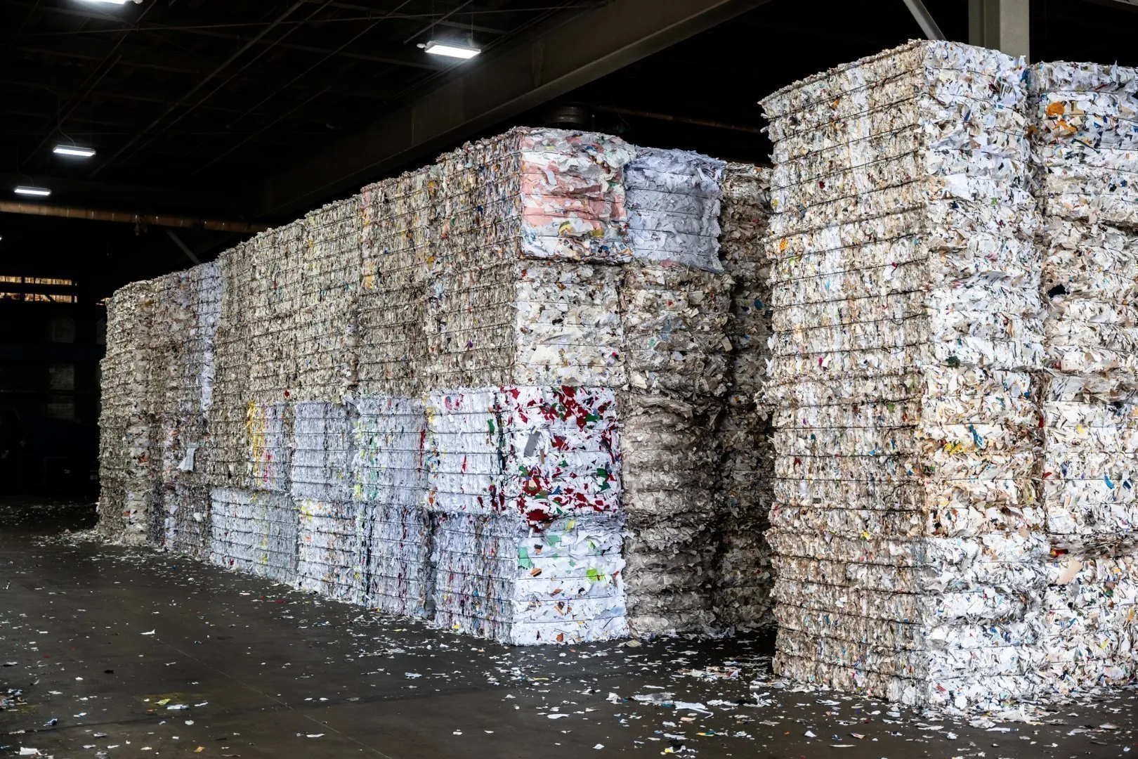 Stacks of compressed mixed‑paper and cardboard bales inside a recycling facility, showing how Casella processes recovered fiber for reuse.