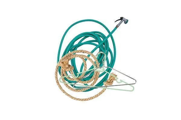 Green garden hose, tan rope, and two metal clothes hangers arranged together with a red prohibition symbol over them, indicating these items are not allowed for recycling. 