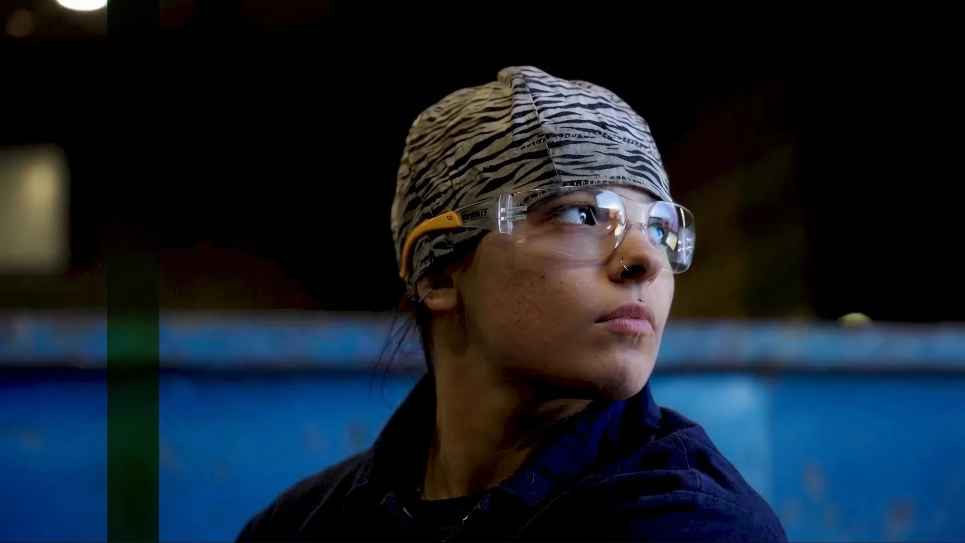Casella worker wearing safety glasses and protective gear in an industrial facility.