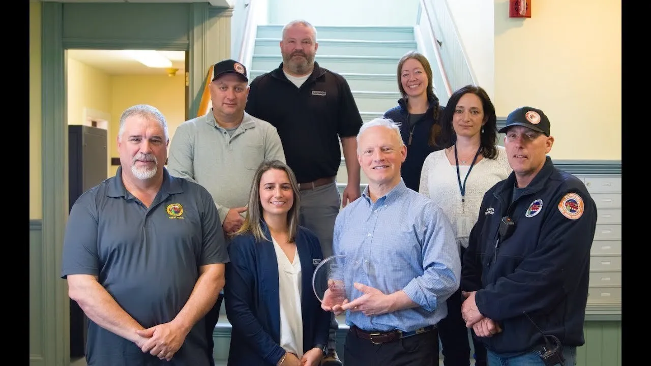 Video highlighting Biddeford, Maine’s community recycling efforts, featuring scenes of curbside recycling bins being inspected and tagged, local educational events with Casella representatives, and committee meetings reviewing contamination reduction strategies