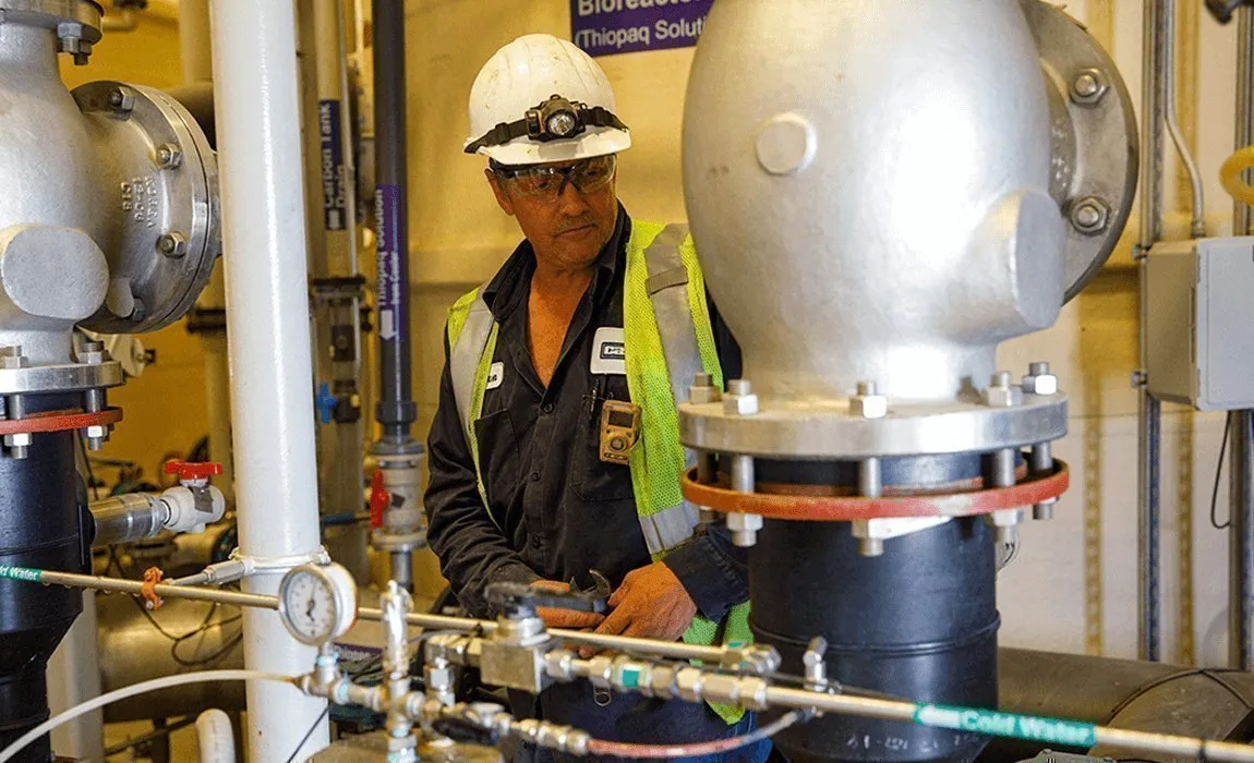 Casella technician inspecting a Thiopaq bioreactor system in an industrial facility.